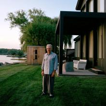 man on grass next to house 