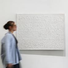 Woman walking by white abstract painting by Kim Fonder 