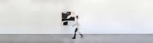 This is a motion blur image of a person walking in front of a Holly Addi painting titled Saint Pierre Des îles. The painting is 48x 48 and is blue, black, grey and white and is an abstract landscape 