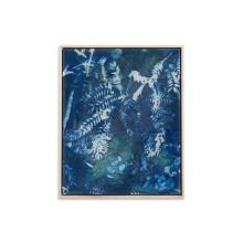 Time Will Tell by Kristen Abbott  A framed piece of contemporary art featuring a cyanotype print of ferns and leaves. The blue-tinted background contrasts with the white silhouettes of the botanical elements, creating a tranquil and natural aesthetic. Crafted with Cyanotype On Silk and Paper, the light-colored wooden frame enhances its serenity.